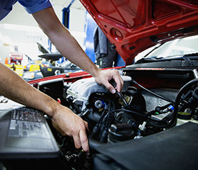 car mechanic working in vehicle engine bay